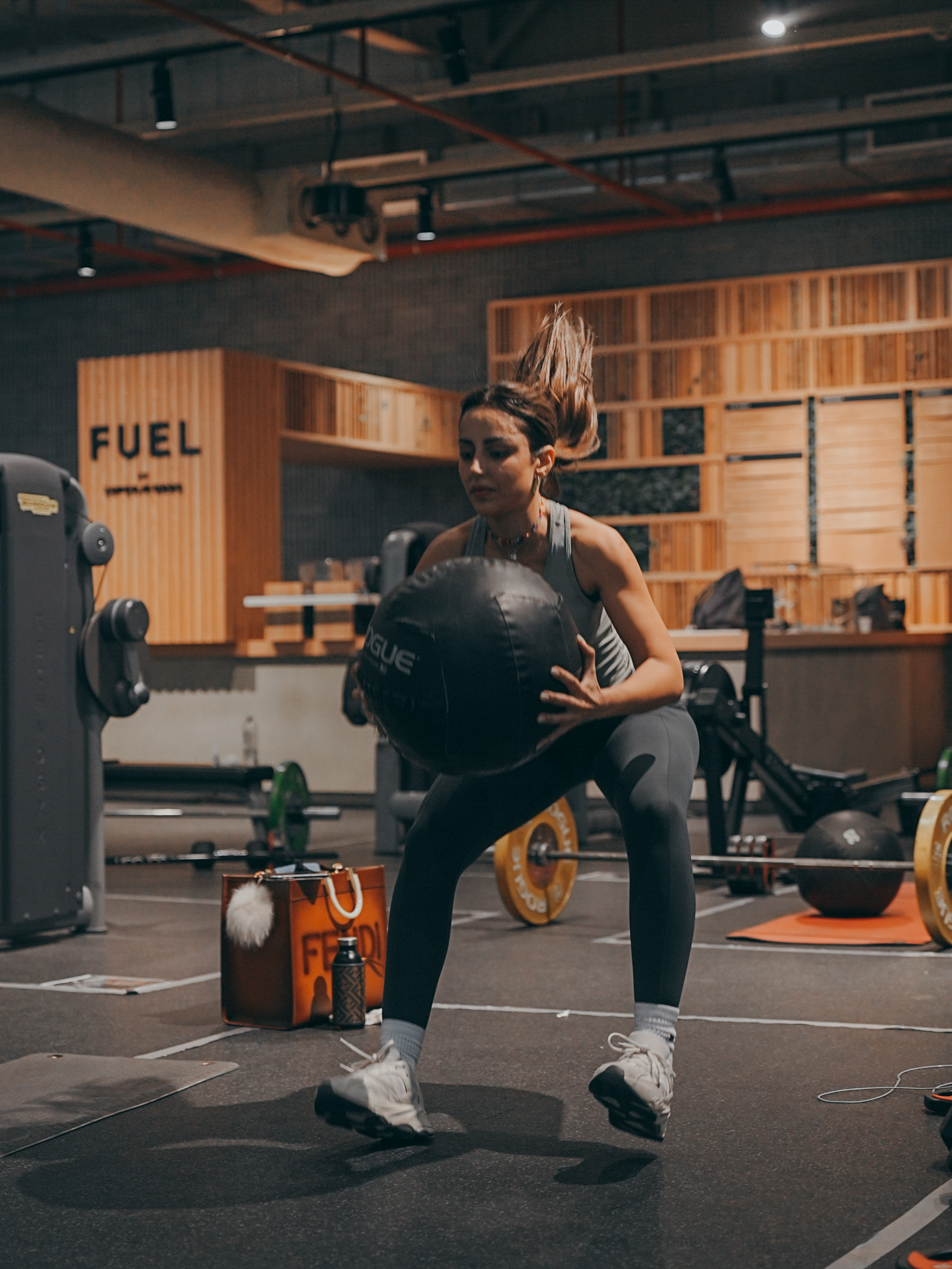 Athlete performing sandbag training exercises in professional gym setting